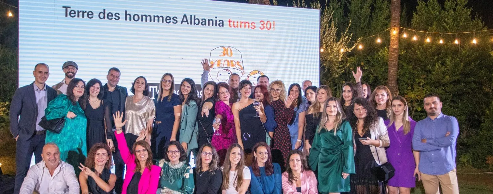 The Tdh Albania team and guests on stage in front of a “Terre des hommes Albania turns 30!” screen